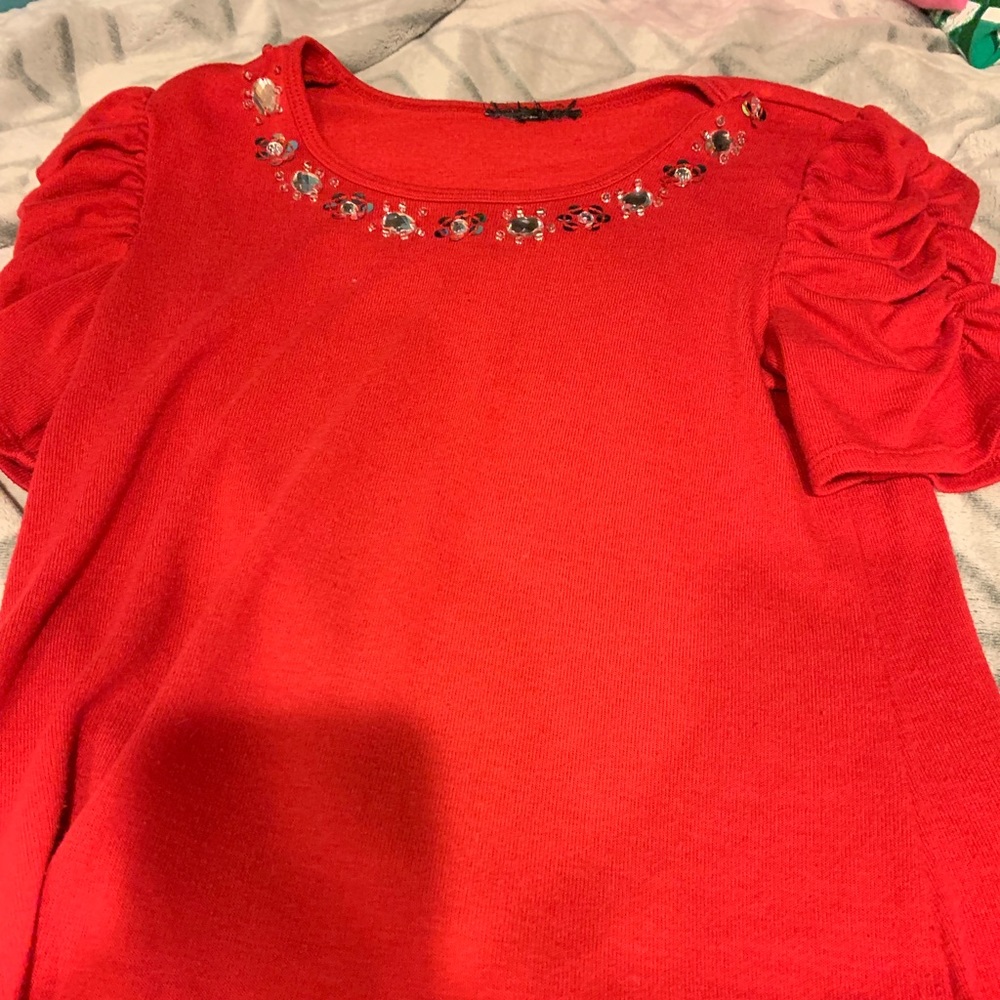 Red top with charms on neckline.